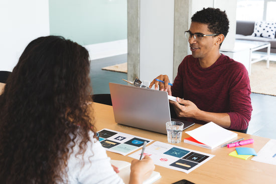 An employee collaborates with his team during a logo selection meeting. | Do you need Logo Design and Branding Services? We are here to help make your business vision a reality. | LunaSola Designs